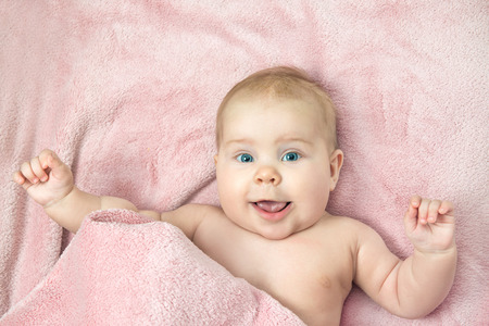 smiling child lying on the bedの写真素材