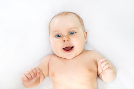 smiling child lying on the bedの写真素材