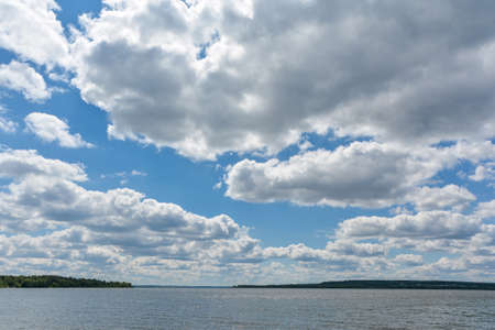 white cumulus clouds on a blue sky on a sunny dayの写真素材