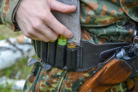 a male hunter inspects a rifle before hunting