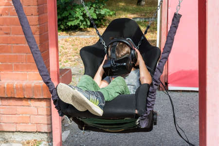 a boy plays a game using a virtual reality headset outdoors