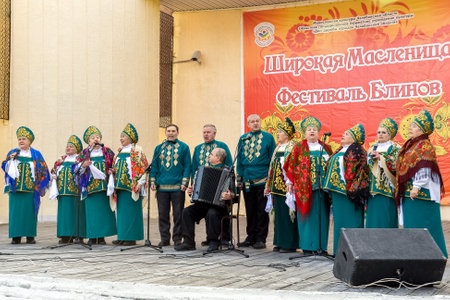 Chelyabinsk, Russia, March 2, 2014. Russian national holiday of farewell to winter. Slavic holiday Maslenitsa. Russian folk choir performs on the open-air stage.のeditorial素材