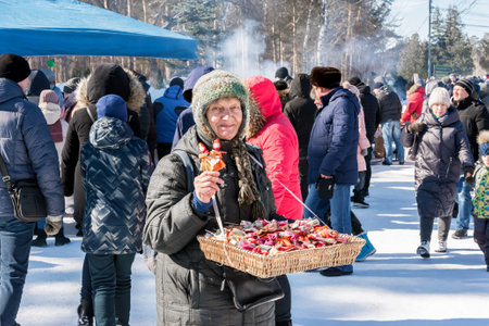 Chelyabinsk Russia March 13 2021 An elderly woman sells handmade souvenirs at the Maslenitsa festivalのeditorial素材