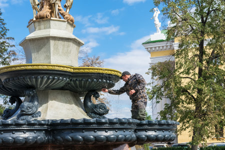Chelyabinsk Russia September 12 2020 a worker in overalls repairs a fountain on a pedestrian street in the city centerのeditorial素材