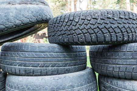 Environmental protection. Old worn-out tires lie in a pile in the landfill.