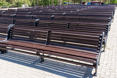 Empty benches stand on an open stage in a city park.の写真素材
