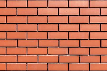 The texture of a stone wall made of smooth red brick. As a natural abstract background.