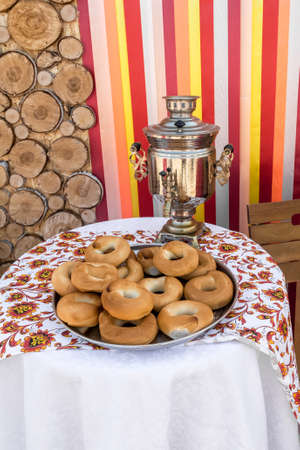 An old samovar and a plate of bagels are on the table. As a holiday decoration and natural...
