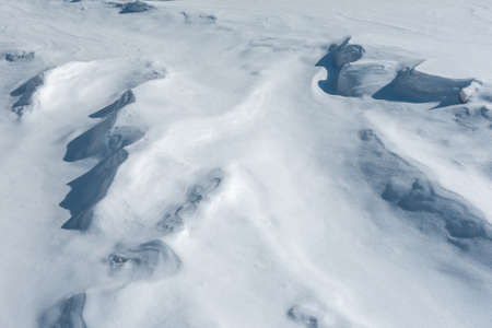 Winter background and snow texture. The wind created patterns on the snowy surface after the snowfall.の写真素材