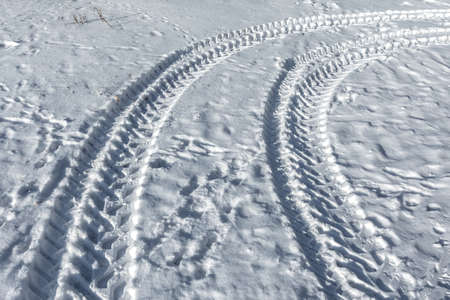 Traces of a wheeled tractor in the snow. Winter snow patterns.の写真素材