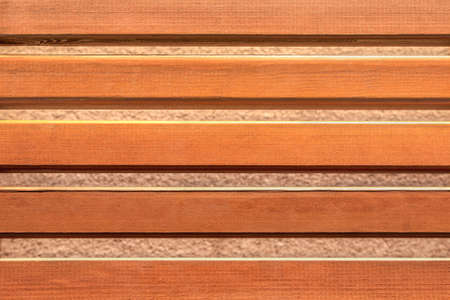 Decorative wooden fence made of pine slats close-up. Texture and pattern of natural wood.