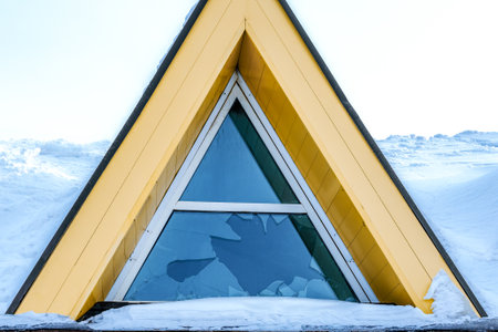 An abandoned house with a broken window was covered with a snowdrift after a snowfall. winter season.の写真素材