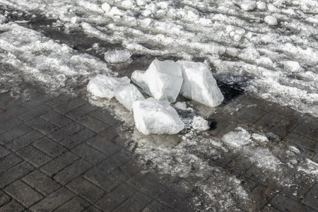 Melting snow and ice on a paved sidewalk on a spring day. spring mood.