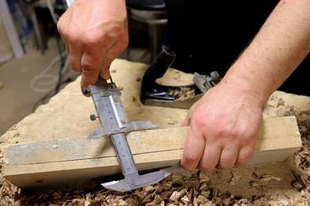 Hands with a tool on the background of a carpentry workshop. Photo in high quality.