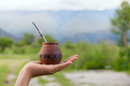 Yerba mate in a traditional calabash gourd, dry mate hand, space for your textの写真素材