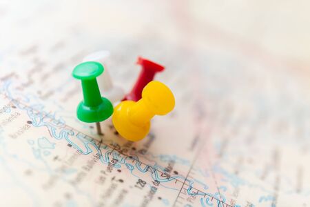 Travel destination points on a map indicated with colorful thumbtacks and shallow depth of field...