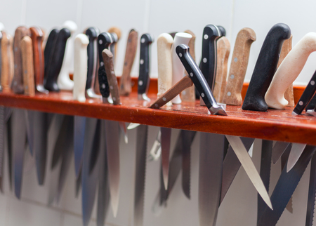 Many large knife hanging wooden storage knife in the kitchen of restaurant stock photoの写真素材