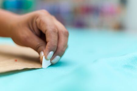 Closeup of Women fashion designer's hands marking with chalk on cloth in workshop stock photoの写真素材