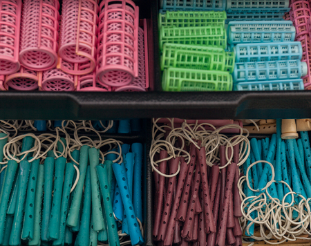 A stack of pink hair rollers Colored hair curlers in different shapes Stock photoの写真素材