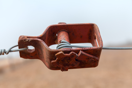 Old wire tensioner of a wire fence in a field closeupの写真素材