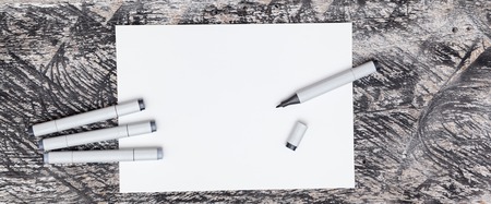 Art markers on white sheet of paper on the surface of a wooden table Mock up marker drawing