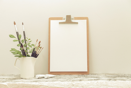 The clipping board mock up on the white table and Art brushes. with haze effectの写真素材