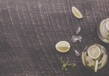 Fresh cocktail Mojito with ice lemon and mint on a dark wooden rustic tableの写真素材