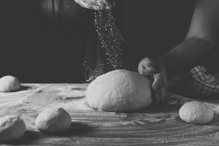Chief baker preparing dough for bread in a bakery. Kitchen professional.の写真素材