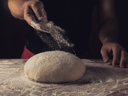 Chief baker preparing dough for bread in a bakery. Kitchen professional.