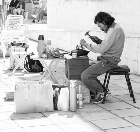 Buenos Aires, Argentina. July 14, 2019. Street craftsman, engraver. Engraves the inscriptions on the vessels for mate teaのeditorial素材