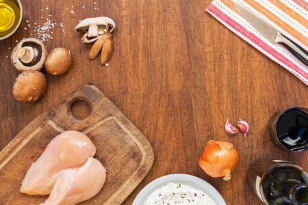 Raw fillet. Cooking Chicken. Bread with flour, starch and spices. Lemon, fresh champignons, onions, garlic, wine, salt and olive oil. Wooden cutting board. Top layoutの写真素材