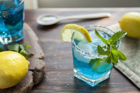 Alcoholic cocktail surrounded by ingredients such as lemon, salt, sugar, ice. Stock photoの写真素材