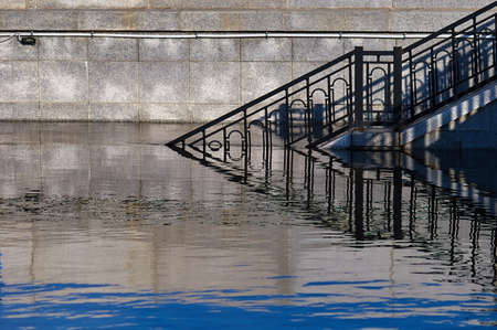 Flooded granite staircase of the city embankment.の写真素材