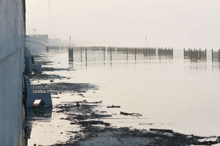 The beginning of the flooding of the lower tier of the granite embankment. Foggy morning before sunrise. City of Blagoveshchensk, Russia.の写真素材