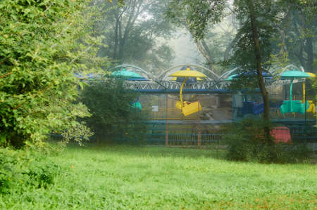 Attraction Carousel in a foggy park of culture and recreation in the city of Blagoveshchensk,...