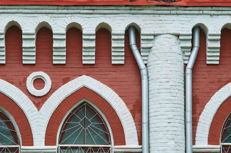 Part of the facade of an old brick shop building from the beginning of the 19th century. Two downpipes. Blagoveshchensk, Russia.の写真素材