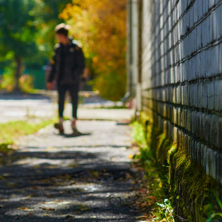 Abstract vintage tone movement. A blur of a street and a guy walking towards you along a brick wall...
