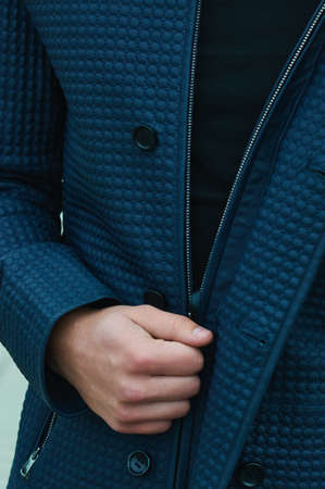 A man's hand opens the zipper on a leather jacket. Close-up photo. Beautiful texture of the material.の写真素材