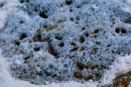 Melting ice floe in the spring on the banks of the Amur River. Warm spring weather. Abstract view of a natural phenomenon. Selective focus.の写真素材