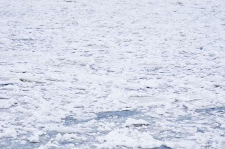 Snow-covered ice on the river during a snowfall. Winter texture.の写真素材