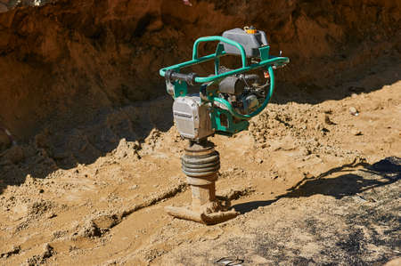 Vibratory rammer gasoline on the road construction site. Without people. Sunny day.の写真素材