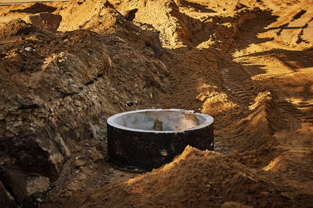 A site for the reconstruction of underground utilities on a city street. Sand and concrete ring.の写真素材