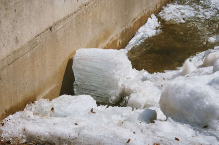 Part of the city embankment made of concrete. Background from shards of ice. ice texture. Shallow...