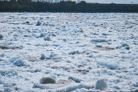 Melting ice on the river in spring. Ice drift time. Natural structure. Needles in the sun.