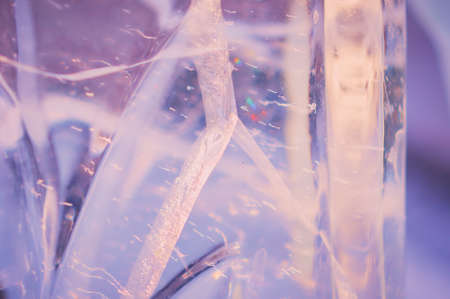 Fragment of an ice figure in the rays of the sun. Focus inside the material. natural texture. Refraction, reflection and optical distortion. Diffraction of light. selective focus.の写真素材