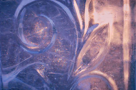Fragment of an ice figure in the rays of the sun. Christmas natural pattern. Focus inside the material. Refraction, reflection and optical distortion. selective focus.の写真素材