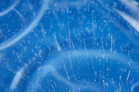 Air bubbles rising from the bottom frost in transparent blue ice. Ice pattern and texture. Optical distortion and refraction of light.の写真素材