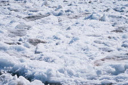 Ice drift on the Amur River. Melting ice floes in spring. A heap of blocks and fragments. Sunny day. Glare and shadows.の写真素材