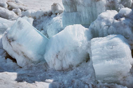 Melting ice floes in spring. A heap of blocks and fragments. Sunny day. Ice drift on the Amur River. Drifted ice pieces. Glare and shadows.の写真素材