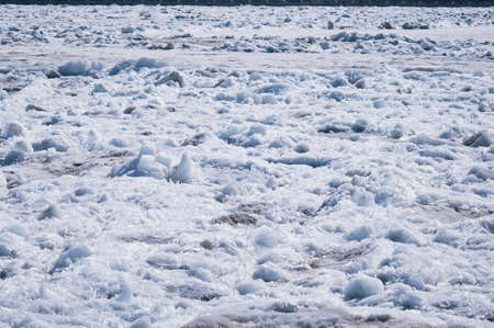 Ice on the river in spring on a sunny day. Texture from fragments of ice floes. seasonal warming.
